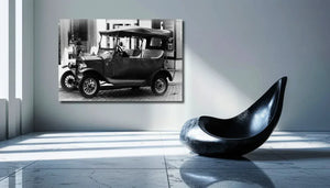 Black and white vintage car photo print hanging on a modern living room wall