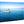 Small motorboat with people cruising on calm blue ocean under clear sky