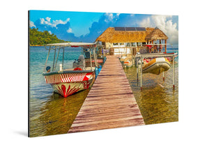 Acrylic photo print of a tropical dock with boats, clear water, and a thatched-roof hut.