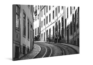 Black and white acrylic photo print of a curved city street with tram tracks and historic buildings
