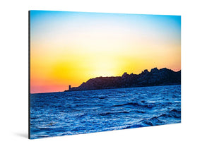 Acrylic photo print of vibrant ocean waves with a rocky coastline at sunset