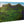 Glossy acrylic photo print featuring a lush green mountain landscape under blue sky