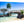 Acrylic photo print featuring a tropical beach scene with a wooden bridge, palm trees, and clear water.