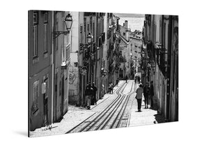 Black and white acrylic photo print of a European street with tram tracks and pedestrians.