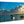 Acrylic photo print of serene beach scene with boats, child in water, and dramatic sky.