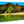 Glossy aluminum photo print with tropical beach, palm trees, and mountain view
