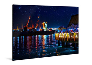Night cityscape photo on aluminum, waterfront pier, lights reflecting on water, starry sky