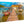 Aluminum photo print of a tropical dock with boats and thatched-roof hut over clear water