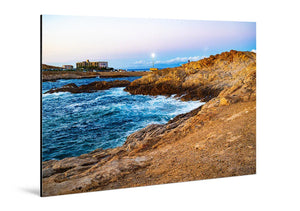 Glossy aluminum photo print of a vivid rocky coastline with blue waves at sunset