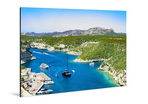 Glossy aluminum wall art with a vivid coastal landscape, yachts on blue water, green hills