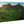 Glossy aluminum wall art print of lush green mountain landscape with blue sky