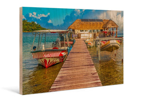 Direct print on wood of a tropical dock with boats, thatched hut, and clear turquoise water