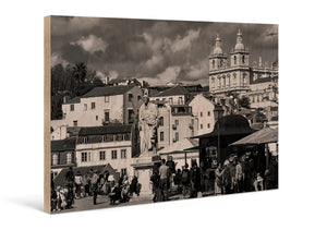 Sepia cityscape photo print on wood featuring historic buildings, statue, and people outdoors