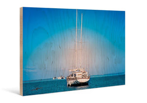 Sailboat anchored on blue ocean, printed on wood with natural grain texture