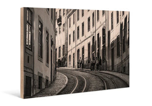 Sepia print of a curved tram street with historic European buildings on wood panel