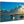 Photo print on wood featuring a serene beach sunset, boats, and clouds over calm water.