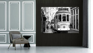Modern living room with gray armchair, side table, and black and white tram cityscape wall art