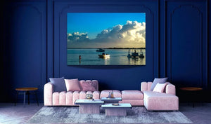 Modern living room with pastel pink sofa and large ocean landscape wall art featuring boats on water.
