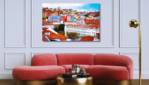 Framed cityscape wall art above modern pink velvet sofa in elegant living room