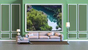 Modern living room with green walls, large river landscape artwork, beige sofa, and lamps