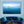 Elegant living room with blue velvet sofa and wall art of two people in a boat on calm ocean