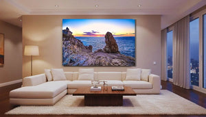 Modern living room with large wall art of a rocky seaside sunset and calm ocean view
