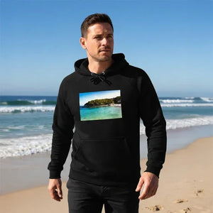 Man wearing black hoodie with beach landscape print, walking on sandy ocean shore