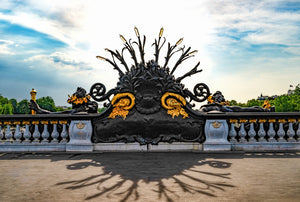 Image du candélabre noir et doré du pont Alexandre III à Paris sous un ciel bleu