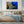 Coral reef wall art above bed in modern bedroom with blue decor and bedside lamps