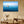 Coastal wall art featuring boat on blue ocean in modern minimalist living room decor