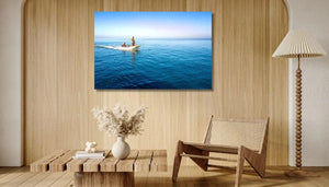 Coastal wall art featuring boat on blue ocean in modern minimalist living room decor