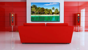 Modern living room with red sofa, speakers, and tropical beach wall art