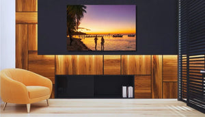 Modern living room with orange armchair, wooden panel wall, and sunset beach canvas art