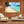 Modern living room with wood wall, armchair, coffee table, and large beach canvas art