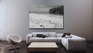 Modern living room with striped wall, large black and white beach landscape art, grey sofa