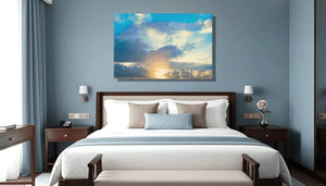 Modern bedroom with a large cloudscape sky photo print above the bed, blue and white decor