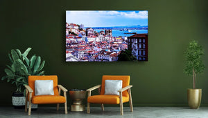Modern living room with orange chairs, green plants, and cityscape wall art