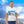 Man wearing white t-shirt with a scenic sky and sunrise art print, blue sky background