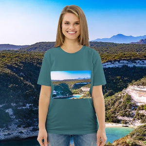 Smiling woman wearing teal t-shirt with scenic nature landscape print, standing outdoors