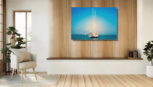 Framed sailboat photography print with blue sea and sky, displayed in a modern living room
