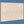 Light wooden photo mounting board with two keyhole slots on a blue background