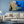 Modern living room with beige sofas, blue wall, and coral reef wall art above the couch.