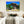 Modern bedroom with nature landscape wall art above bed, neutral colors, sunlight through window