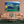 Mountain landscape plexiglass wall art above peach sofa in modern living room