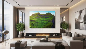 Large acrylic wall art featuring a lush green mountain landscape in a modern living room
