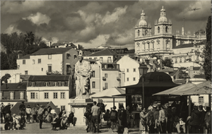 Vintage cityscape with statue, historic cathedral, old buildings and people in a European square