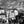 Black and white cityscape with statue, historic buildings, and people in a European square