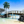 Wooden footbridge over tropical lagoon with palm trees and clear blue sky