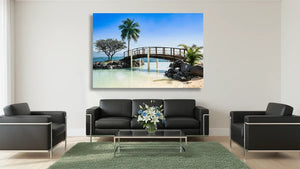 Modern living room with a beach bridge wall art, palm trees, and coastal decor accents.