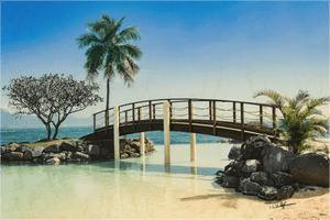 Tropical wooden bridge over calm water with palm trees, rocks, and clear blue sky